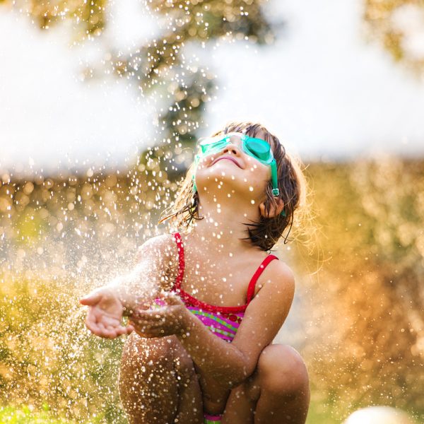 Cute little girl having fun outside in summer garden